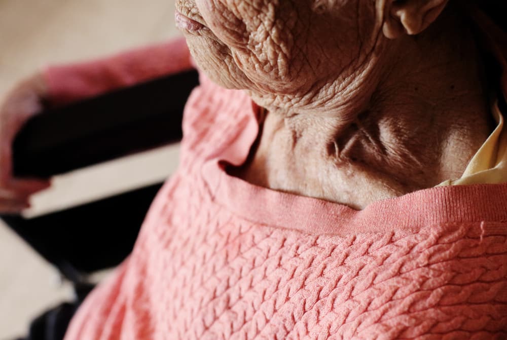 Aged woman sitting in wheelchair in Nursing Home