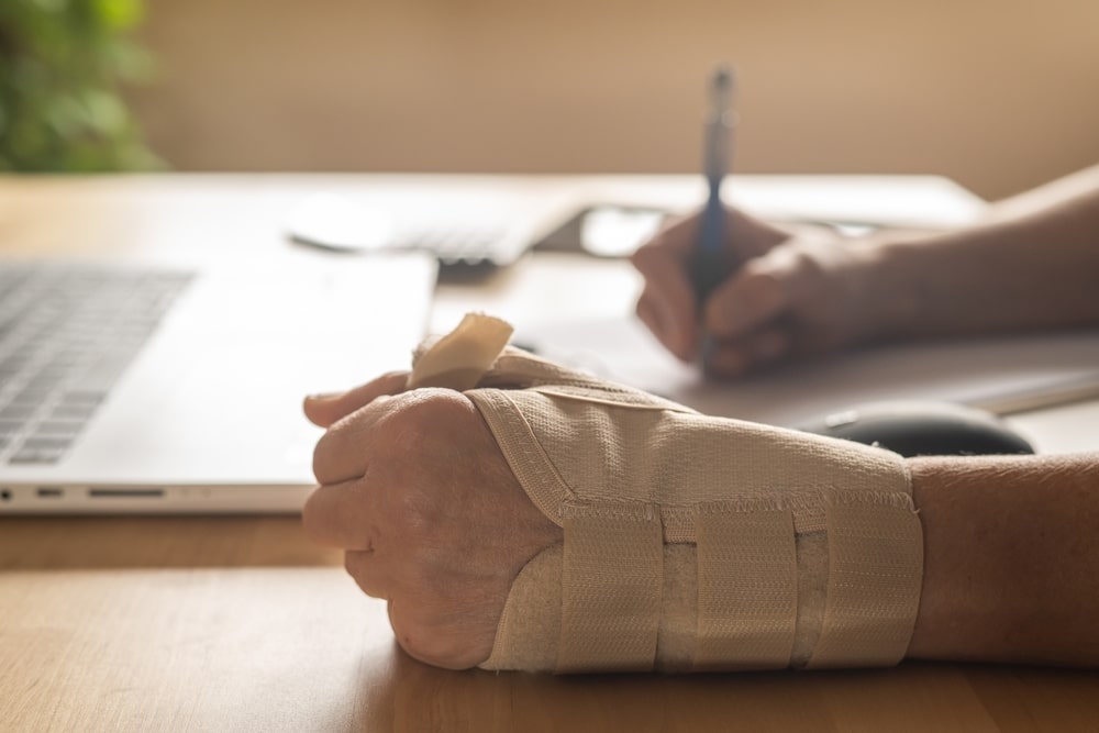 Injured worker with a wrist brace filing a workers’ compensation claim in Miami