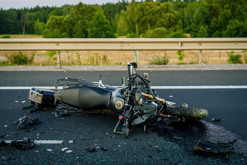 Motorcycle wreck on a highway with debris showing severe crash damage and potential insurance coverage shortfalls in Florida