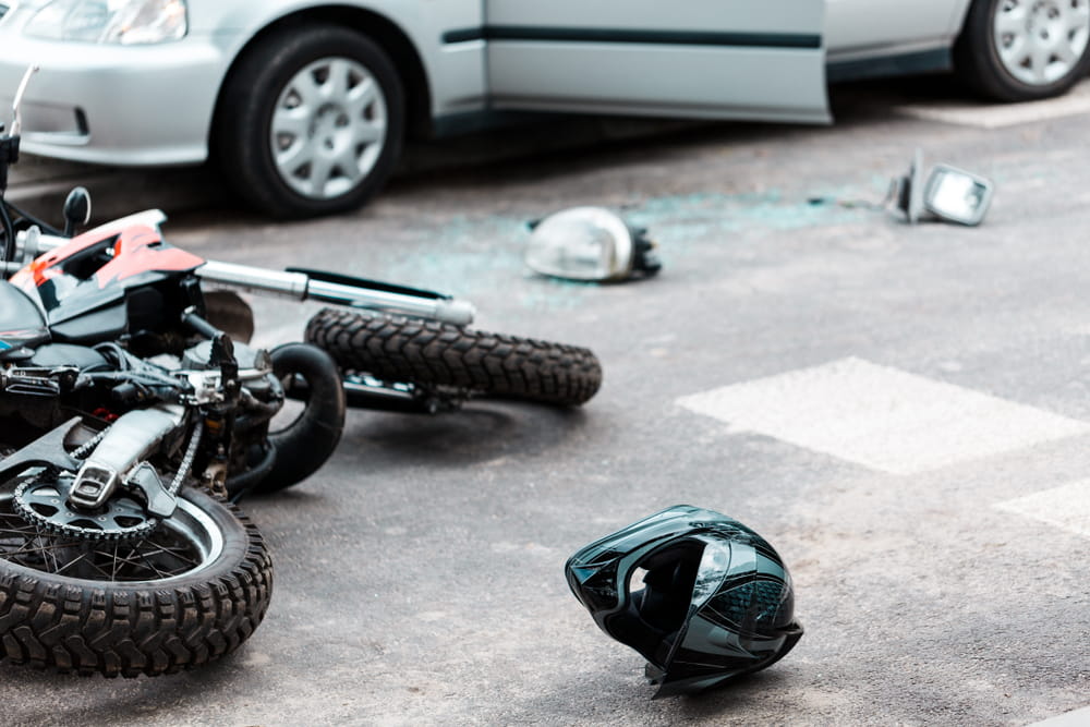 Motorcycle helmet on the road near a crash scene highlighting rider vulnerability and perception bias in Florida injury claims