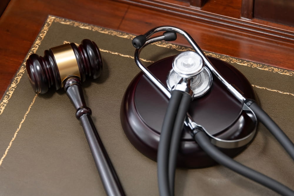 Mazo judicial y estetoscopio sobre escritorio simbolizando la intersección entre medicina y derecho en casos de negligencia médica en Florida