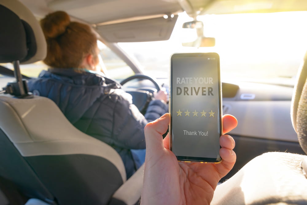 Passenger rating a rideshare driver on a smartphone highlighting Uber and Lyft trip context and insurance coverage during active rides in Florida